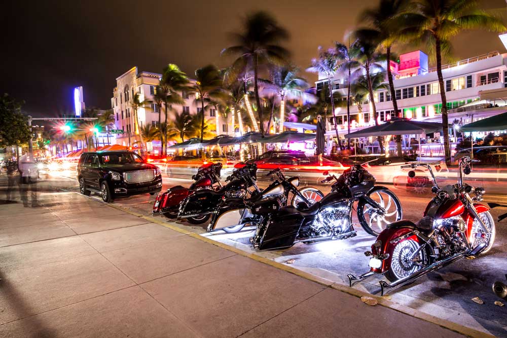 Motorcycles parked on Ocean Drive at night, showcasing the vibrant nightlife.
