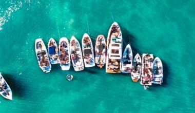 Aerial drone view capturing various sizes of boats anchored near the beach of an island in Biscayne Bay