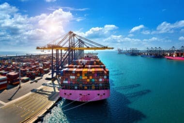 Bird's-eye view of a cargo ship and shipping containers in the harbor