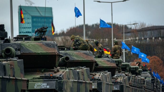Vilnius, Lithuania - 11 25 2023: A column of German armored vehicles during NATO parade. High-quality photo. Waving NATO flags.