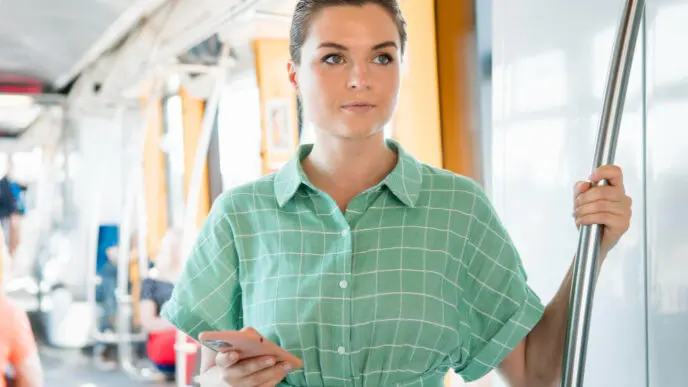 A European woman managing her work in public transportation, viewed from the front