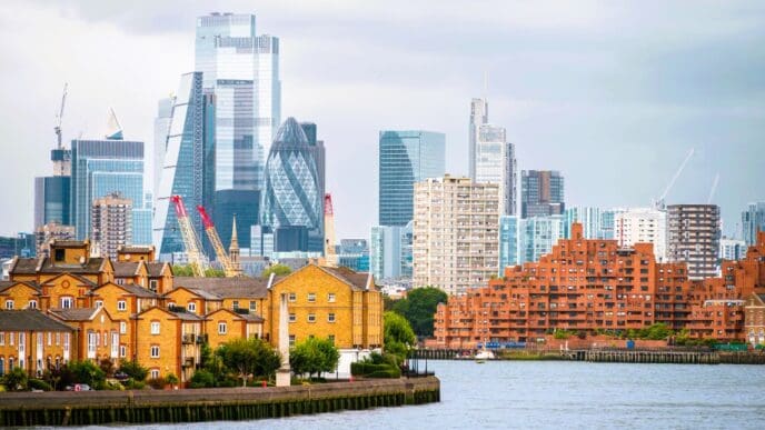 Cityscape of London, UK, featuring the Thames River with a backdrop of financial and residential buildings