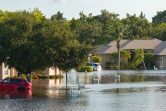 Flooded residential area with underwater houses and cars from storm. Aftermath of natural disaster in southern USA. By Shutterstock.com - Bilanol