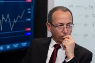 Portrait of a serious and thoughtful financial expert in his office, reflecting a hint of uncertainty