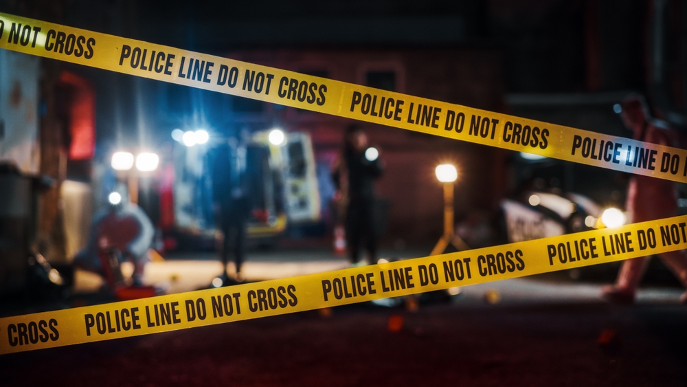 Crime Scene Investigation Team Working on a Murder. Female Police Officer Briefing Detective on the Victim's Body
