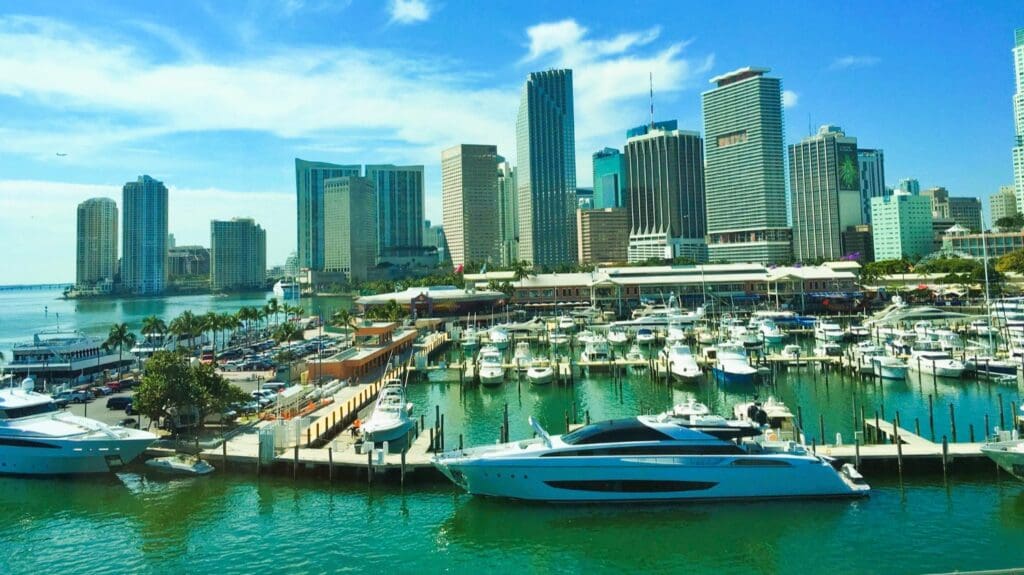 A vibrant image of a marina filled with boats, with the Miami skyline in the background