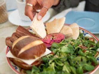 Close-up of a person's hands preparing food on a table.