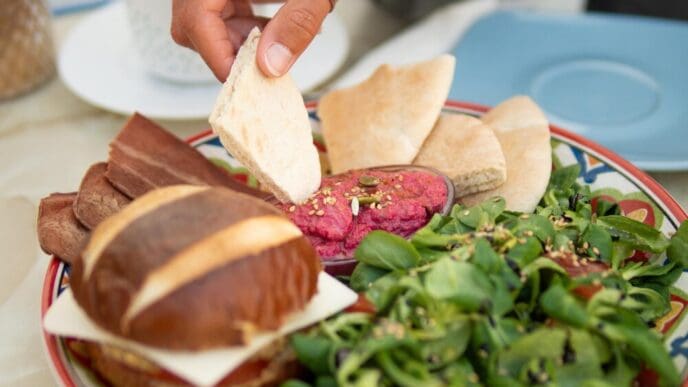 Close-up of a person's hands preparing food on a table.