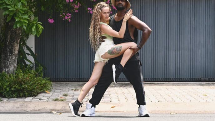 A young couple dances joyfully in the middle of a street.