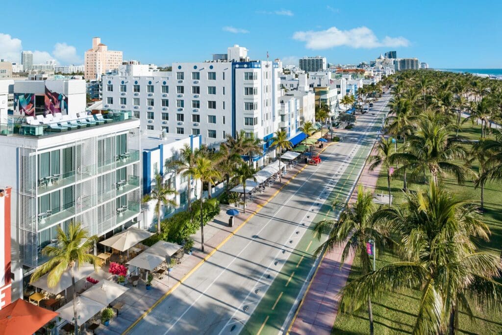 An aerial view of Ocean Drive in Miami Beach, lined with Art Deco hotels and palm trees