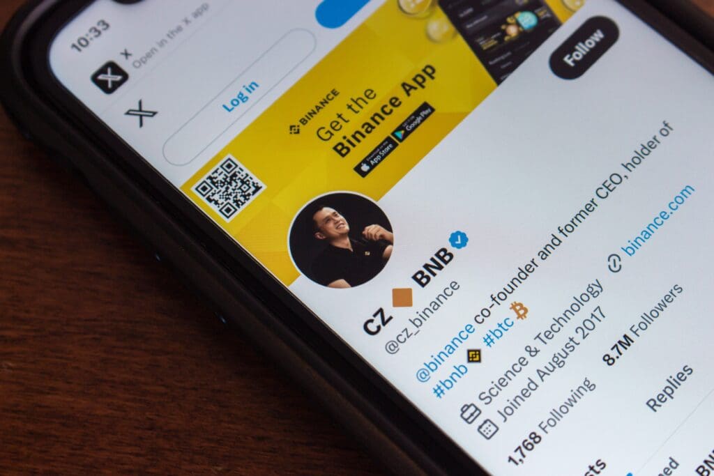 A smartphone screen showing the X (Twitter) profile of Binance co-founder Changpeng Zhao (CZ).