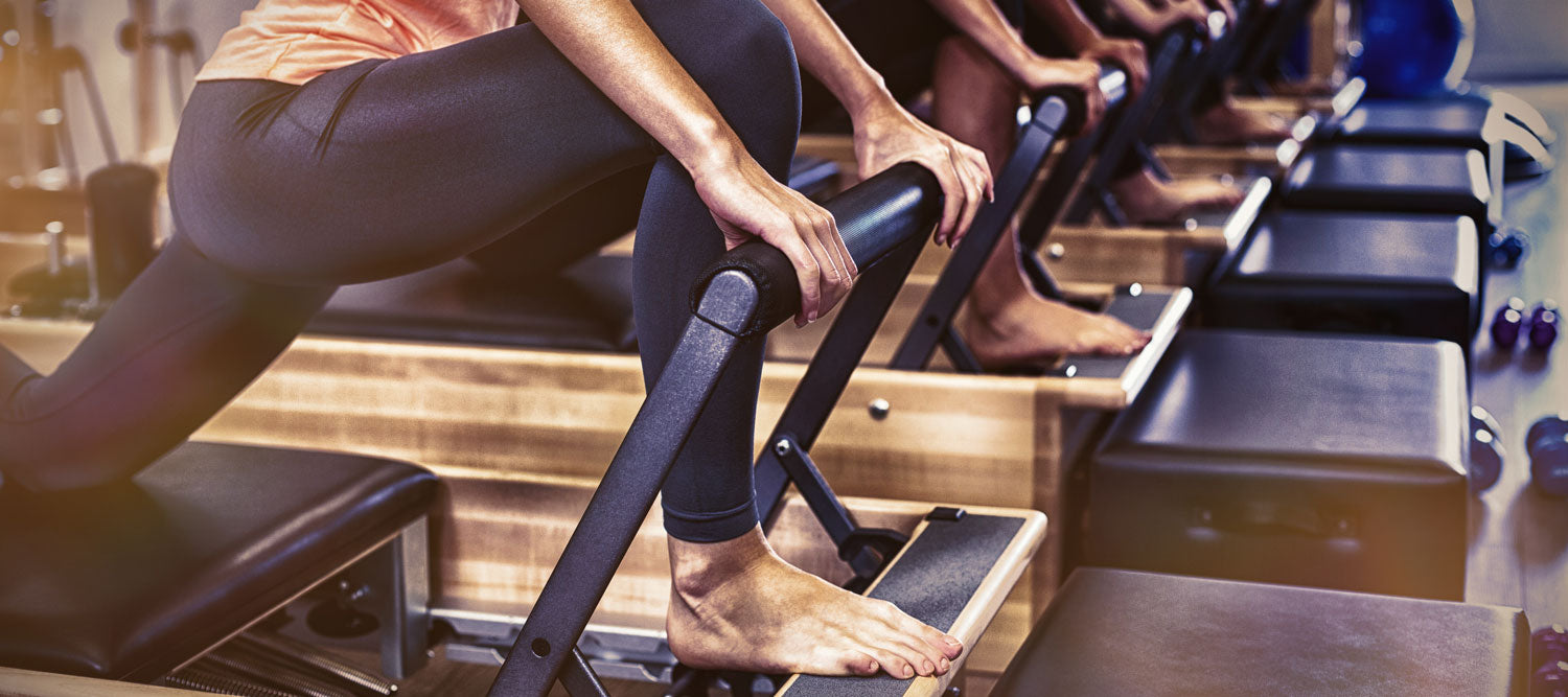 Group of women exercising on Pilates reformer in gym in Miami